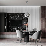 Modern dining area featuring a round black marble table, four gray upholstered chairs, and the Ex-Display Lava Large Pendant Light - Silver above. A black marble feature wall with TV, vertical white panels, and dark wood accents finish the space.