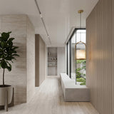 A minimalist hallway with light wooden floors and walls, a large potted plant, the Halorin 1 Light Framed Alabaster Single Pendant Light in soft white & brushed brass, a wide window bench, and tall windows overlooking a small green garden.