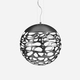 The Elon LED Light Pendant - Matte Black is a spherical contemporary lighting fixture featuring a matte black outer shell with an irregular pattern and a white interior. It hangs from a cable against a plain white background.