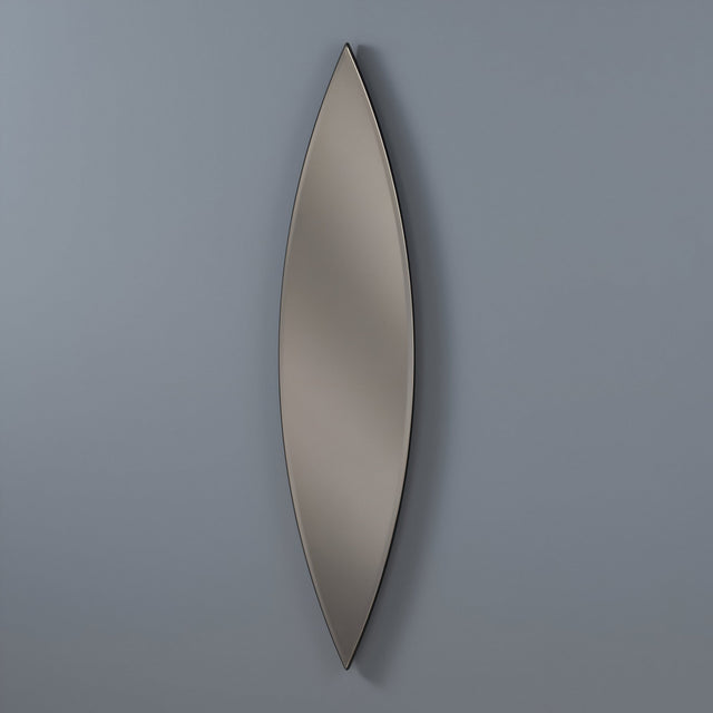 The Aurora Oval Wall Mirror Bronze & Silver (130x30cm) features a tall, narrow oval shape with smooth edges, a sleek modern design, and a subtle metallic frame, mounted vertically on a plain gray wall.