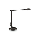 Introducing the Prismora LED Table Lamp 12.5W 4000K - Black, featuring a modern and slim design with an industrial-inspired touch. This sleek black table lamp boasts an adjustable arm and round base, complemented by a circular flat lamp head for enhanced style. Its pivot joint allows for flexibility, while an adjustable LED diffuser maximizes functionality. The lamp's power cord conveniently extends from the base, ensuring ease of use.