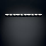 The Phosix Trimless LED Recessed Downlight – 20W, 3000K, Black features a sleek, rectangular design with ten evenly spaced fixtures that offer bright illumination against a dark background. Constructed from durable die-cast aluminum, it ensures a seamless installation that integrates effortlessly into any space.