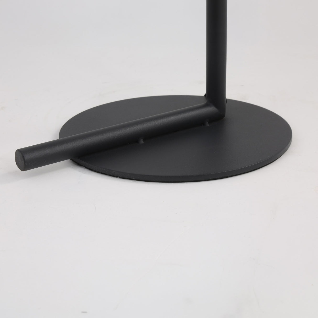 A close-up of the Vetra 1 Light Opal Glass Floor Lamp in black, showing its matte circular base with vertical and horizontal rods, designed for modern spaces, set against a plain white background.