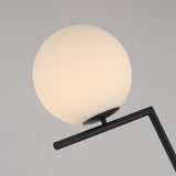 The Vetra 1 Light Opal Glass Floor Lamp - Black features a modern matte black stand with a round opal glass shade, ideal for contemporary interiors, shown against a plain light gray background.