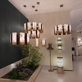 Caelith 8 Light Alabaster Panel Chandelier 600mm in brushed brass, shown in a showroom alongside matching pendants, wall lights, and floor lamps.