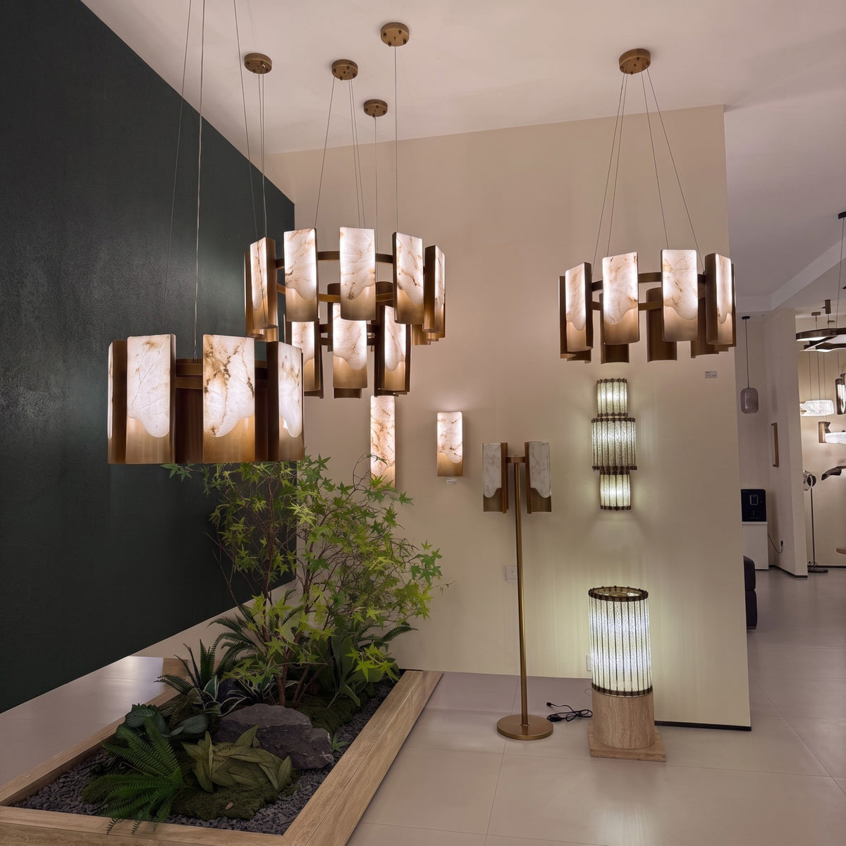 Caelith 10 Light Large Panel Alabaster Chandelier in Brushed Brass, shown in a showroom with circular tiered alabaster panels alongside coordinating pendant and floor lamps.