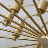 Close-up of the Caldrin 10 Light Tiered Panel Alabaster Chandelier in Soft White & Brass, featuring multiple metal arms with bulbs, set against a white ceiling.