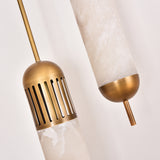 Close-up of the Zerith LED alabaster tube pendant light, showing natural alabaster cylinders with fluted brushed brass collars and domed brass end caps against a plain white background.