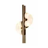The Lyra LED Twin Disc Alabaster Wall Light features two vertical brushed brass rods and alabaster-style white diffusers, emitting soft white light. Its sleek, symmetrical design adds elegance to any space.