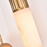 Close-up of the Zerith LED alabaster tube pendant light, showing the natural stone cylinder glowing warm white beneath a fluted brushed brass collar, against a plain light background.