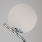 Close-up of the Vetra 1 Light Opal Glass Floor Lamp in grey, featuring an opal glass sphere shade and shiny chrome support, casting soft ambient light against a plain light gray background.