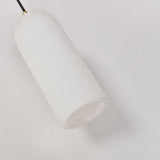 Velmora slim cylindrical alabaster pendant light in soft white, with brass ceiling plate and black flex, shown close-up against a plain background.