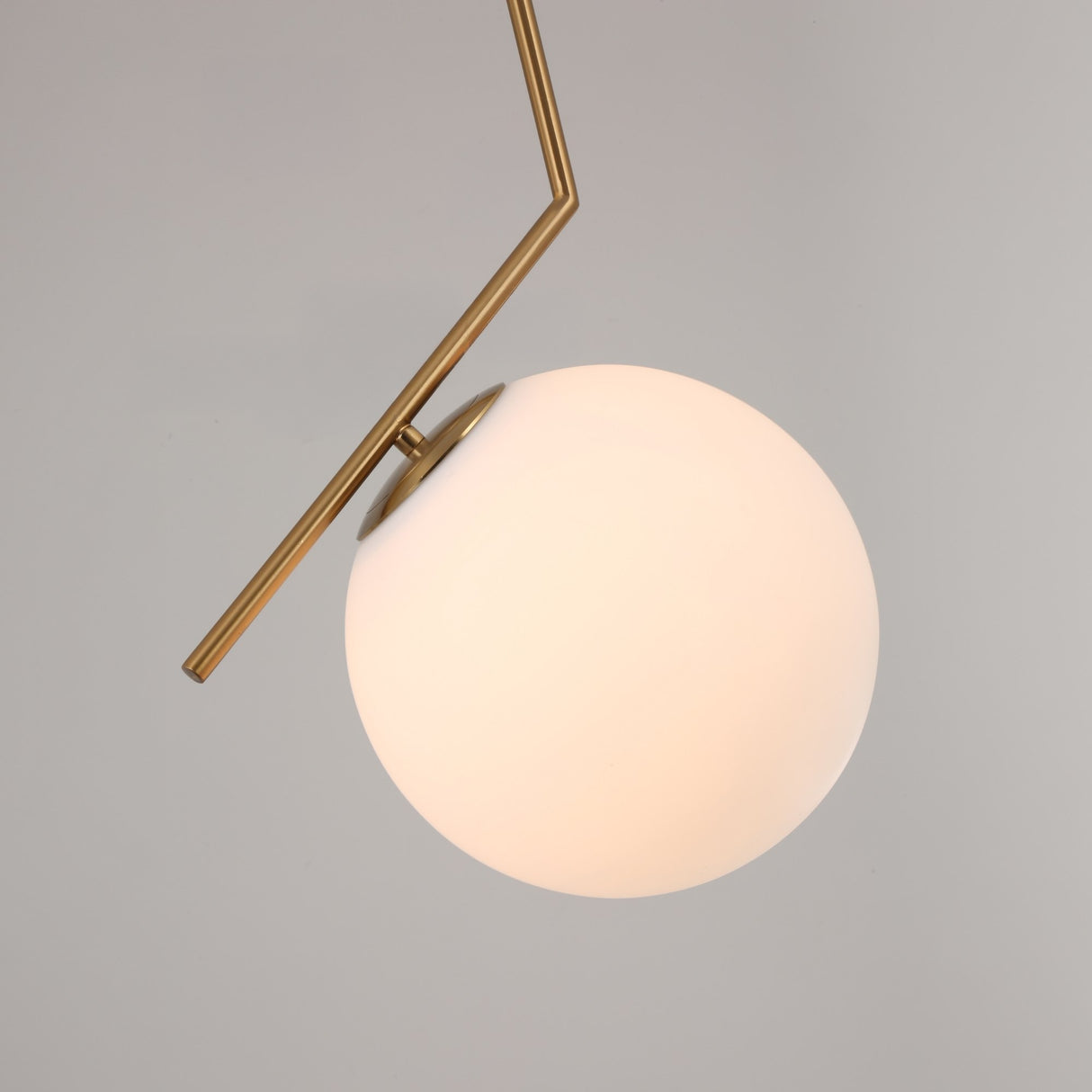 The Vetra Opal Glass Large Pendant Light - Gold features a round, frosted white globe and an angled, gold-finished rod, set against a plain light gray background.