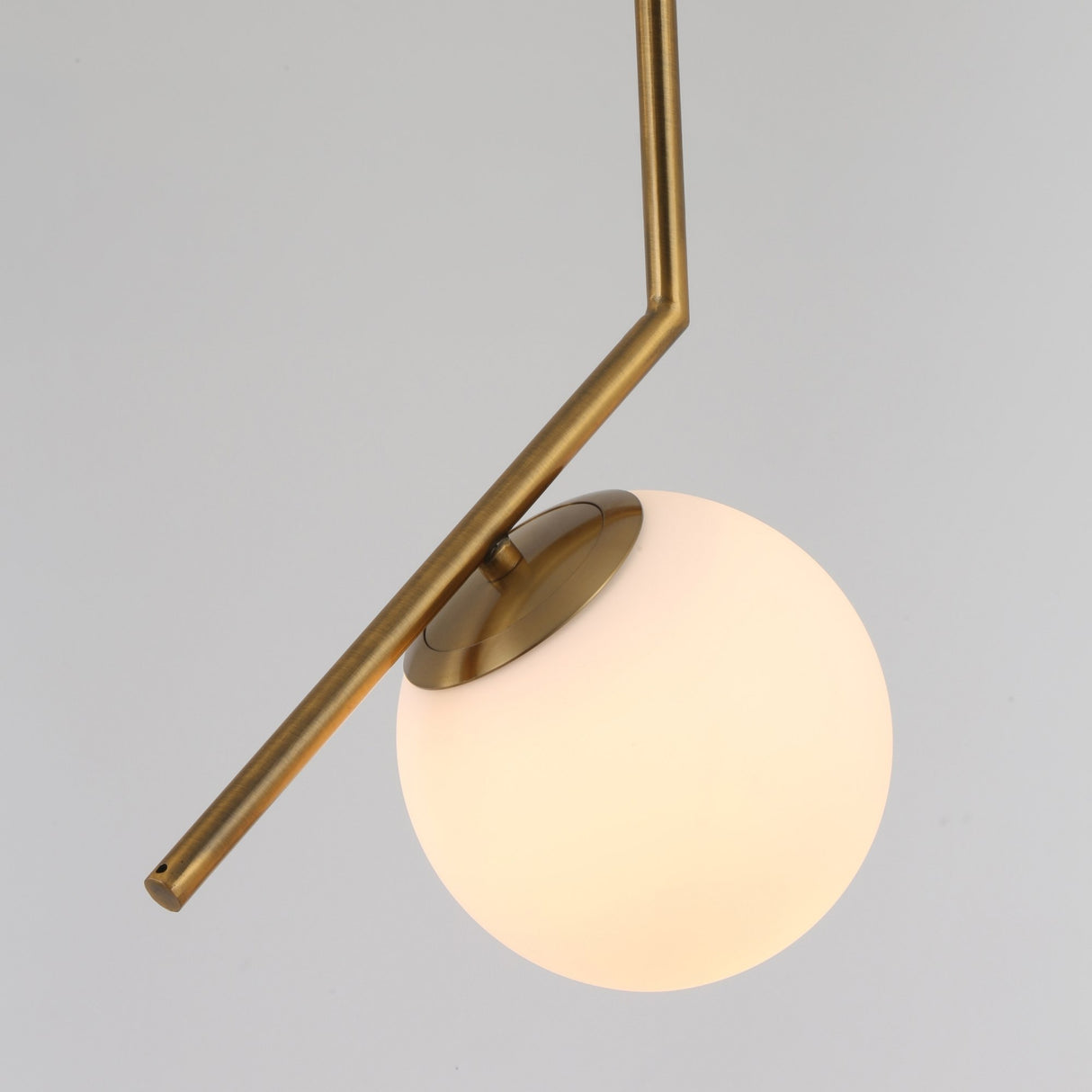 The Vetra Opal Glass Large Pendant Light - Gold features a matte brass angular rod and a round opal glass globe, shown against a plain light gray background.