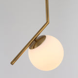 The Vetra Opal Glass Large Pendant Light - Gold features a matte brass angular rod and a round opal glass globe, shown against a plain light gray background.