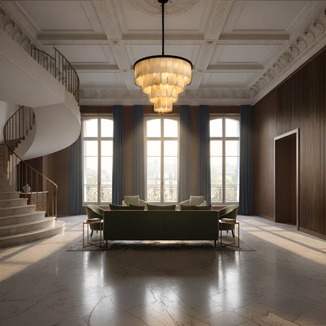 Luxurious living room with marble floors, tall windows with blue curtains, and a spiral staircase. The Auravel 48 Light Extra Large Tiered Alabaster Chandelier glows overhead, illuminating the elegant green sofas and armchairs.