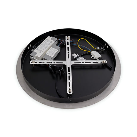 A circular light fixture lies face down, exposing its inner components. Visible are a metallic support frame, wiring, and electrical elements. The fixture combines modern elegance with its round, gold edge and smooth surface, reminiscent of the Fluxa 3 Light LED Cluster Pendant 3000K 60W - Gold.