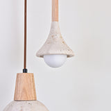Vantoro pendant light with a cone-shaped travertine shade in light beige, wood stem, and exposed opal globe bulb, shown beside a second pendant with a rounded wood cap and stone-look shade.