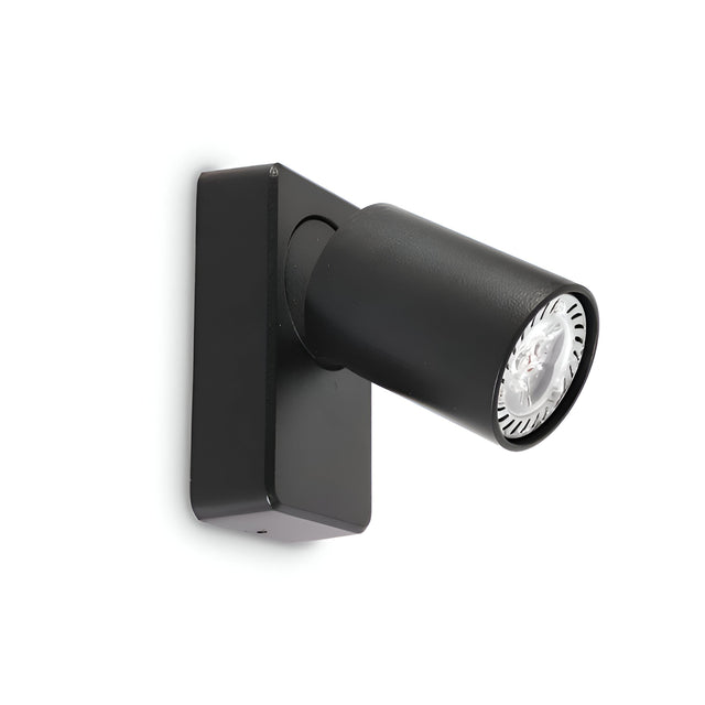 Introducing the Sparkeon-1 Single Spot Light in black, a cylindrical wall-mounted spotlight with a rectangular base and adjustable LED lighting. It boasts a sleek, modern design that seamlessly integrates with an industrial style, making it ideal for interior lighting. The spotlight is slightly angled downward, providing focused illumination.