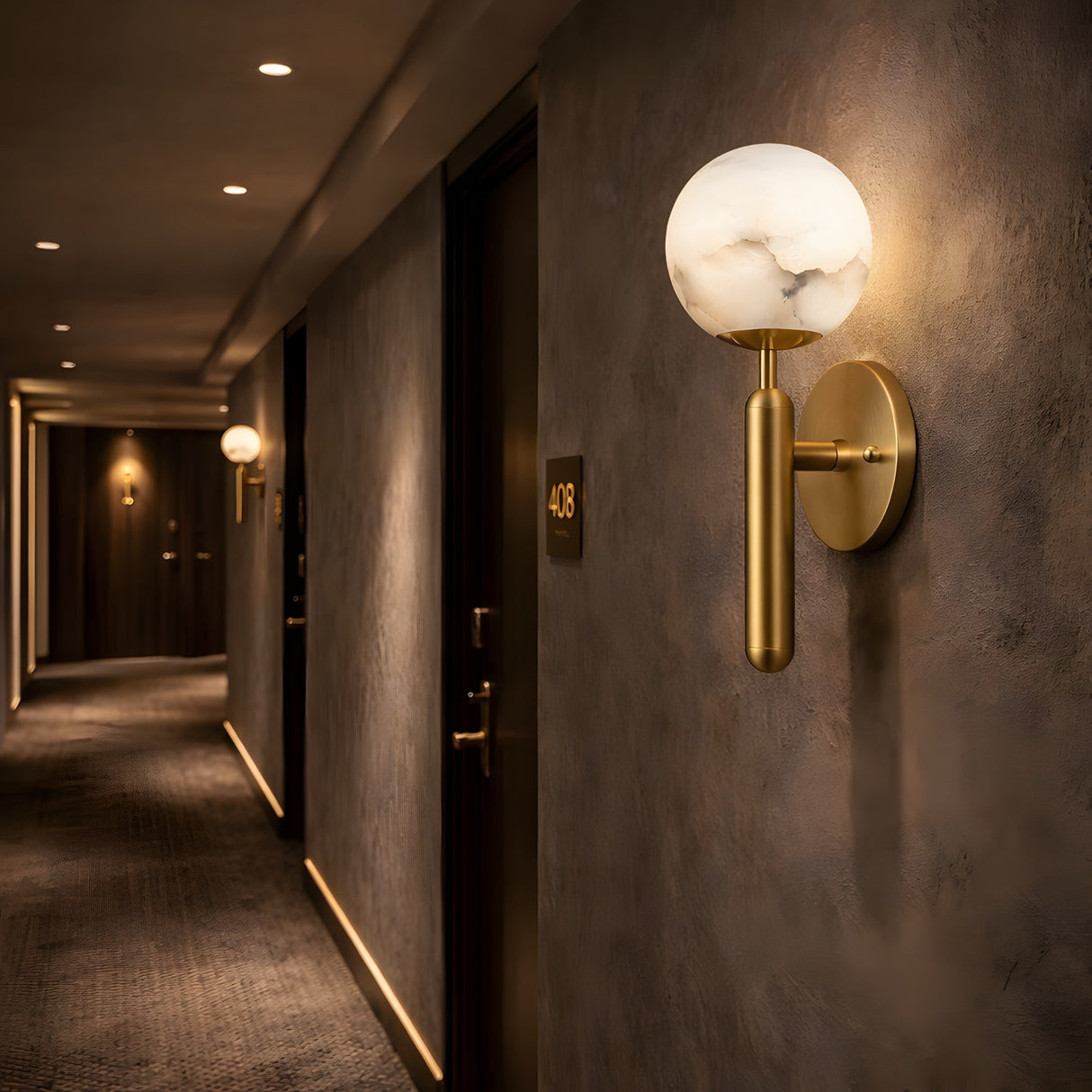 A dimly lit hotel hallway features Etoile 1 Light Sphere Alabaster Wall Lights in Soft White & Brushed Brass, textured gray walls, dark carpet, and numbered doors—including one marked 408.