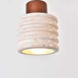 Rivano Ribbed Travertine Pendant Light with ribbed light beige stone drum, walnut wood top, and glowing E27 bulb, shown against a plain white background.