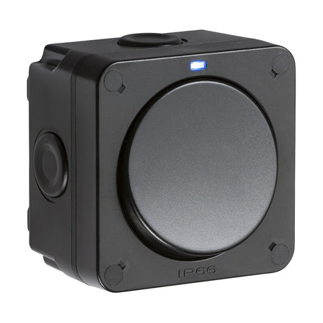 The IP66 20AX 1 Gang SP 2-Way Switch - Black features a square-shaped industrial design with a circular button and a small blue indicator light at the top. It is housed in a durable polycarbonate enclosure and is IP66 rated, providing outstanding dust and water resistance, making it perfect for outdoor use.