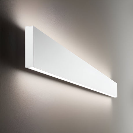 The Flux LED Linear Wall Light 32W 3000K - White casts a soft, white glow on a light-colored wall. Its sleek, rectangular shape and clean, minimalist design incorporate energy-efficient dimmable technology to produce an elegant and contemporary ambiance.