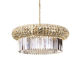 The Enluma Crystal 16 Light Chandelier - Gold is a luxurious lighting masterpiece, featuring a round, layered design with a gold-toned metal frame embellished with sparkling clear and amber crystals. This chandelier hangs beautifully from a chain and includes dimmable functionality to gracefully reflect light.