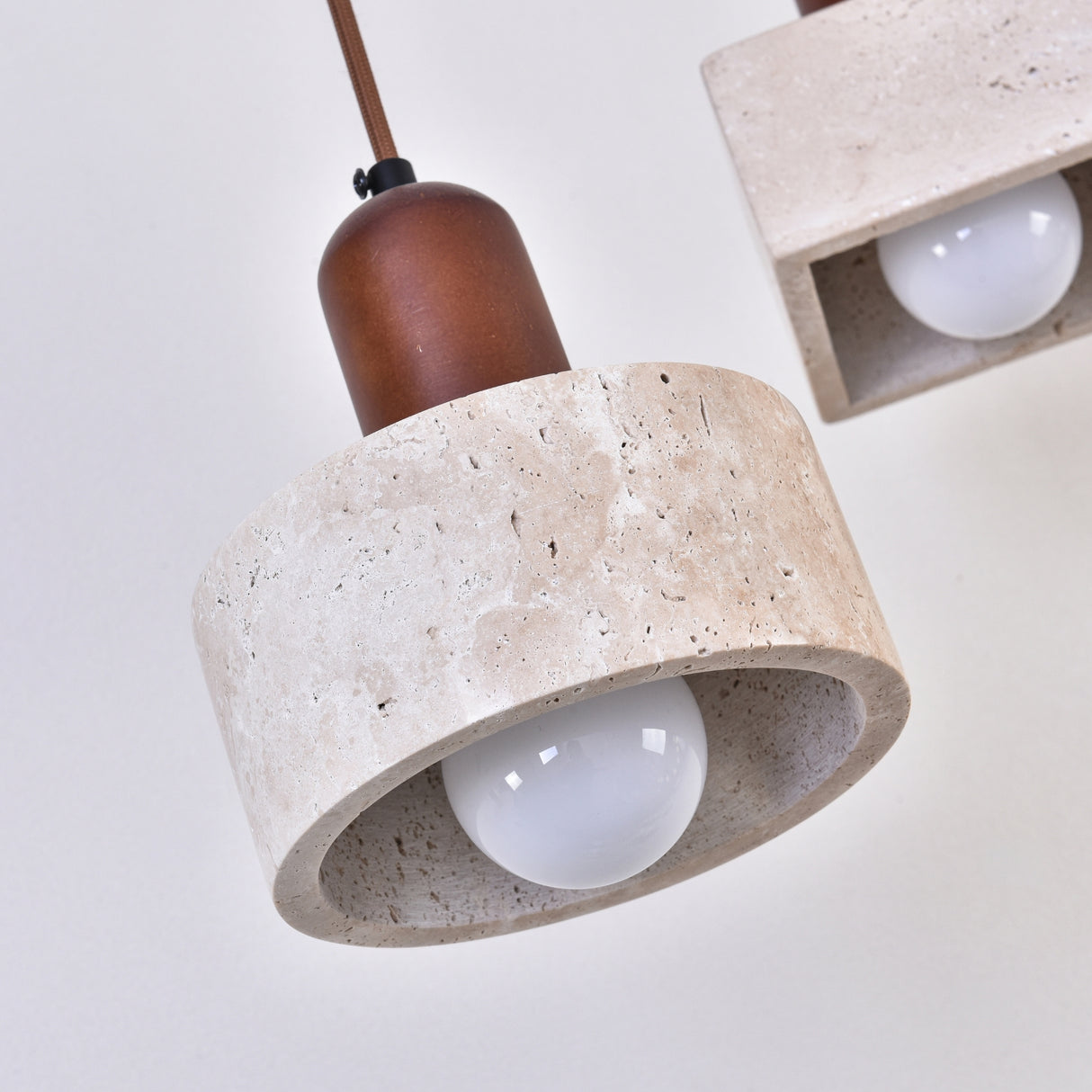 Torvella Travertine Drum Wall Light with a light beige travertine drum shade, exposed E27 bulb, and walnut brown fitting, shown close-up against a plain background.