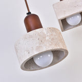 Torvella Travertine Drum Wall Light with a light beige travertine drum shade, exposed E27 bulb, and walnut brown fitting, shown close-up against a plain background.