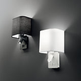 On a gray wall, two sleek Prismia LED Wall Lights are installed. One has a black rectangular shade while the other features a white one. Each lamp is equipped with an adjustable 3W 3000K LED reading light, ideal for late-night reading sessions.