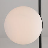 The Vetra 1 Light Opal Glass Table Lamp - Black features a round, white frosted opal glass globe on a sleek vertical black metal pole, set against a light gray background.