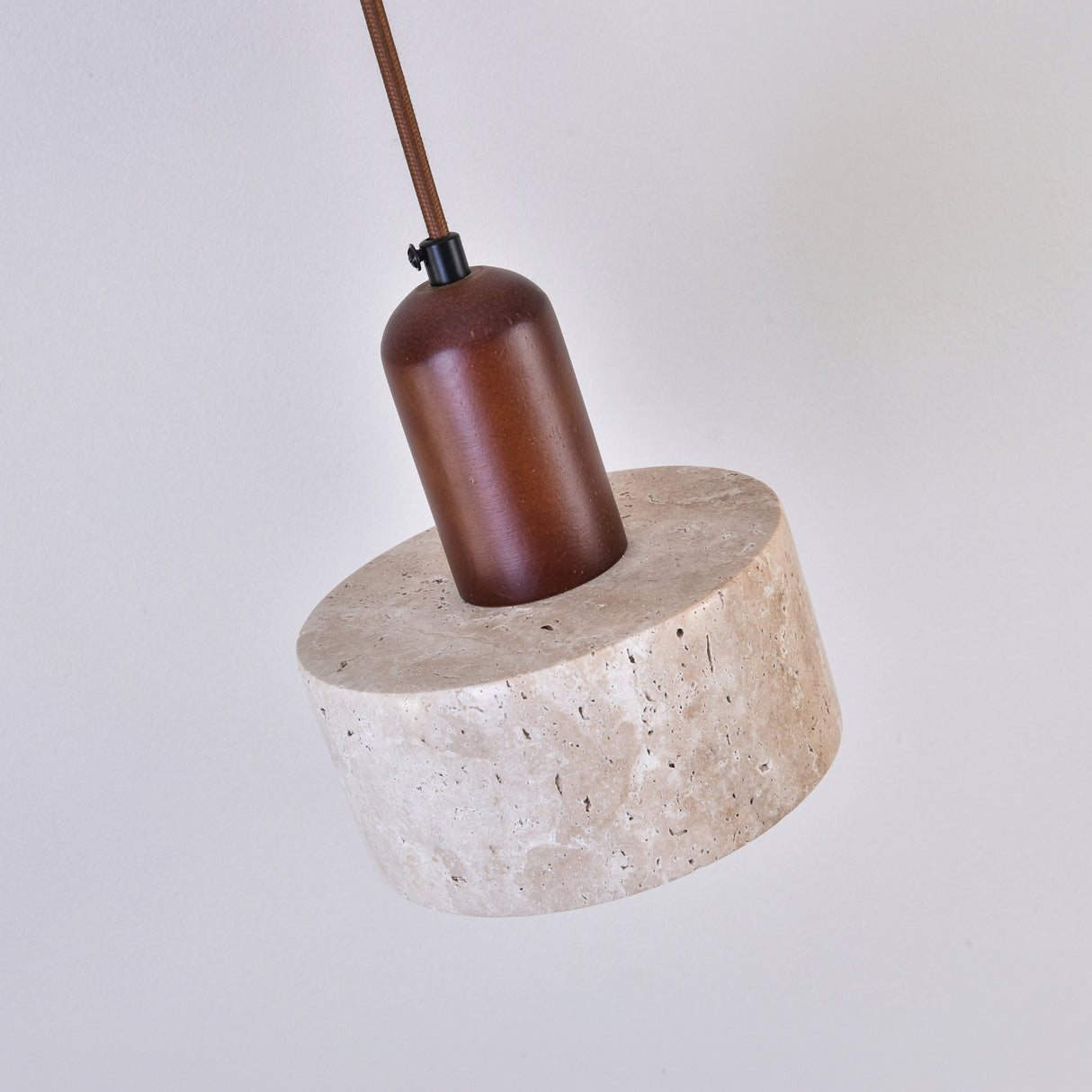 Torvella Travertine Drum Wall Light in light beige travertine with a walnut brown wooden fitting and fabric flex, shown against a plain white background.