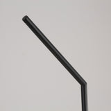 A black metal straw with a bent angle is displayed on a plain, light gray background beside the Vetra 1 Light Opal Glass Table Lamp in black.