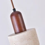 Close-up of the Torvella wall light's walnut brown drum socket cap suspended by a fabric flex above its light beige travertine base, shown against a plain white background.