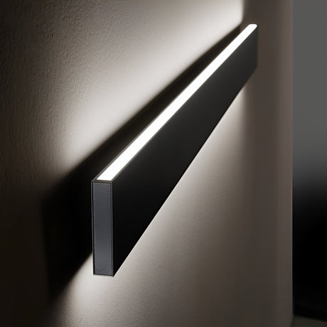 The Flux LED Linear Wall Light 32W 3000K - Black exudes a sleek, modern appearance while emitting a soft, warm glow. When mounted horizontally on a plain wall, it provides gentle illumination with energy efficiency. Its minimalist design showcases a slim, rectangular shape with clean lines and delivers enhanced ambiance through its 3000K cool white light.