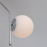 Close-up of the Niori Vetra pendant light showing the opal glass globe mounted off-axis to a polished chrome disc and angled stem.