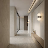 Minimalist hallway with beige stone walls and floors, built-in wooden bench with vases, floor-to-ceiling window, vertical wood accent wall, and Vetra 2 Light Opal Glass Wall/Semi-Flush Ceiling Light in black for modern illumination.
