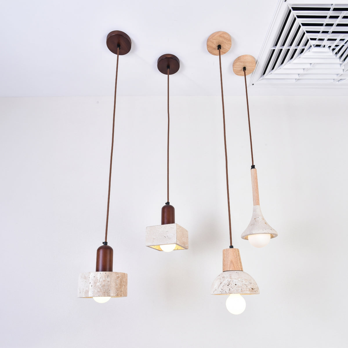 Lunaro 1 Light Travertine Pendant Light in walnut and light beige, cylindrical stone shade with wooden top, shown among similar pendant designs against a plain white ceiling.