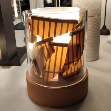 PotLight Glass Table Lamp in terracotta ceramic with clear outer and frosted inner glass cylinders, decorative perforated shade insert glowing from within, on a neutral tabletop setting.
