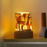 PotLight Glass Table Lamp in terracotta ceramic with clear outer and frosted inner glass cylinders, lit on a wooden shelf beside a ceramic vase.