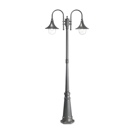 The Lumis Twin Head Lamp Post - Anthracite showcases a sophisticated double-headed design with a tall black structure. It features two elegantly curved arms holding bell-shaped shades and clear glass bulb covers, all supported by an ornate, tapered base for a chic outdoor lighting solution.