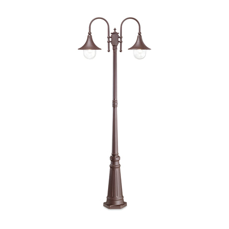 The Lumis Twin Head Lamp Post - Brown is a tall street lamp made from die-cast aluminum, featuring two curved arms with bell-shaped shades that encase clear bulbs. Its classic design and decorative base provide timeless outdoor illumination against a pristine white backdrop.