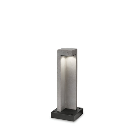 Introducing the Starry Outdoor LED Bollard Light 9W 3000K, featuring a modern geometric design with a rectangular frame. This fixture emits a soft glow from the top and includes an energy-efficient base in grey, complemented by its concrete-like structure that enhances its contemporary appeal. Measuring 49cm in height, it adds sophistication to any outdoor setting.