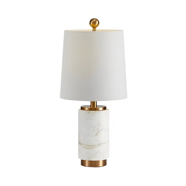 The Valmera 1 Light Cylinder Marble Table Lamp features a white cylindrical marble base, brass accents, and a white tapered lampshade topped with a gold finial.