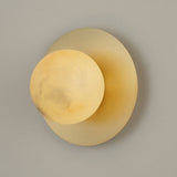 Niori Oria Alabaster Globe Wall Light in brushed brass, featuring a cream alabaster sphere with natural veining on a circular backplate.
