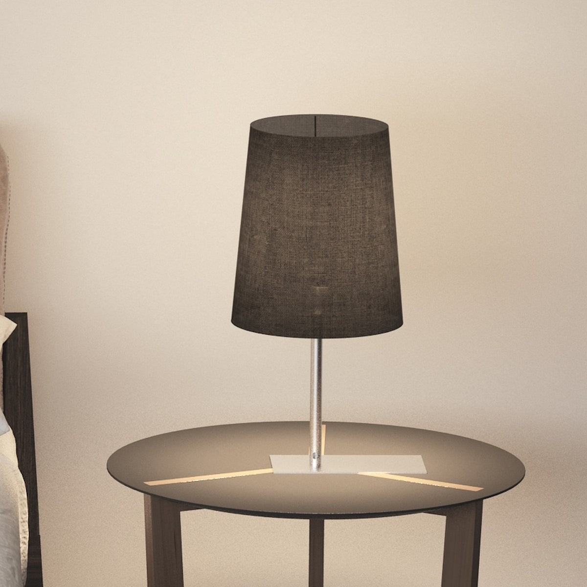 Selmarne Fabric Table Lamp with tapered black cotton shade on a slim satin nickel stem and rectangular base, shown on a round side table in a bedroom setting.