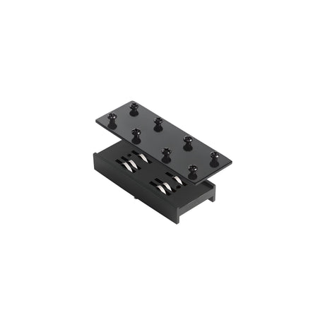 The Prismatic Linear Track Connector - Black displays a sleek, minimalist design with its black rectangular box and detachable lid featuring multiple cylindrical pegs, reminiscent of a modern track lighting connector. Inside, it reveals two parallel cylindrical components that continue the elegant black finish of the track connector style.