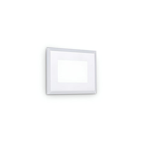 A simple white picture frame with a thin border hangs on a plain white wall. Inside the frame is an empty space, revealing a white background that matches the wall, softly illuminated by the Zenithar LED Outdoor Wall Light 5W 3000K - White.