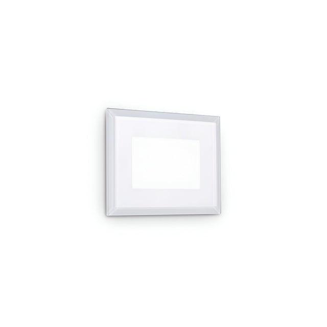 A simple white picture frame with a thin border hangs on a plain white wall. Inside the frame is an empty space, revealing a white background that matches the wall, softly illuminated by the Zenithar LED Outdoor Wall Light 5W 3000K - White.